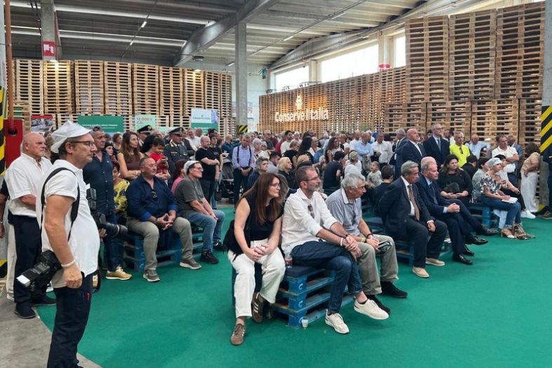 Visitatori all’Open Day 2026 della Smart Factory Conserve Italia di Pomposa, nello stabilimento con i pallet sullo sfondo.